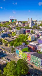 Colourful hillside neighbourhood with a family walking and exploring near bright hotels and shops