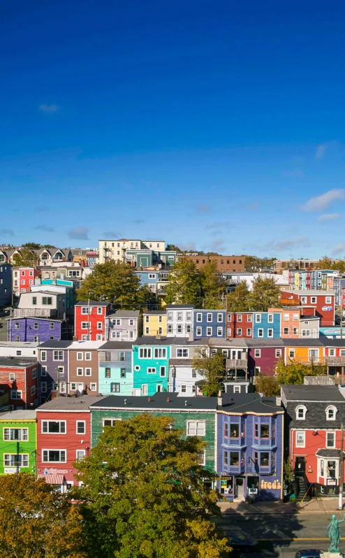 Colourful hillside buildings under a bright blue sky in a vibrant neighbourhood.