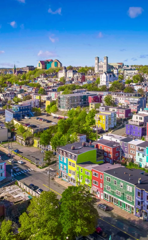 Colourful cityscape view with vibrant houses under a bright blue sky.