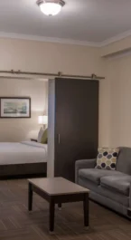 Modern hotel suite with a cosy living area and bedroom, ideal for relaxation.