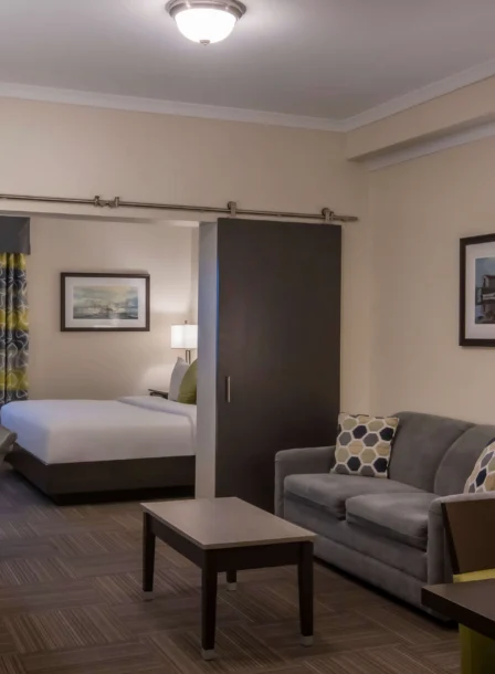 Modern hotel suite with a cosy living area and bedroom, ideal for relaxation.