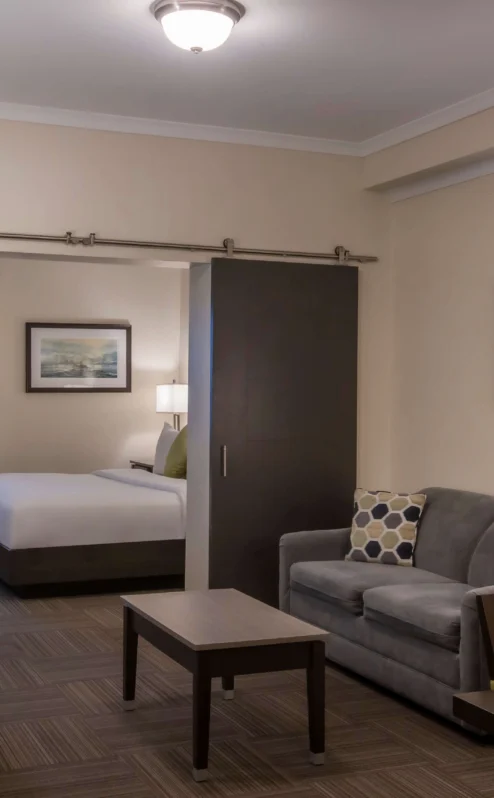 Modern hotel suite with a cosy living area and bedroom, ideal for relaxation.