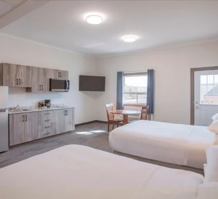 Spacious double room in Crossroads Inn & Suites with kitchenette and cosy dining area.