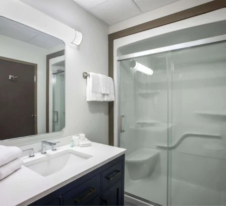 Modern bathroom at Crossroads Inn with spacious shower and elegant vanity.