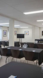 Bright, inviting conference room with tables set for a meeting at Crossroads Inn & Suites.