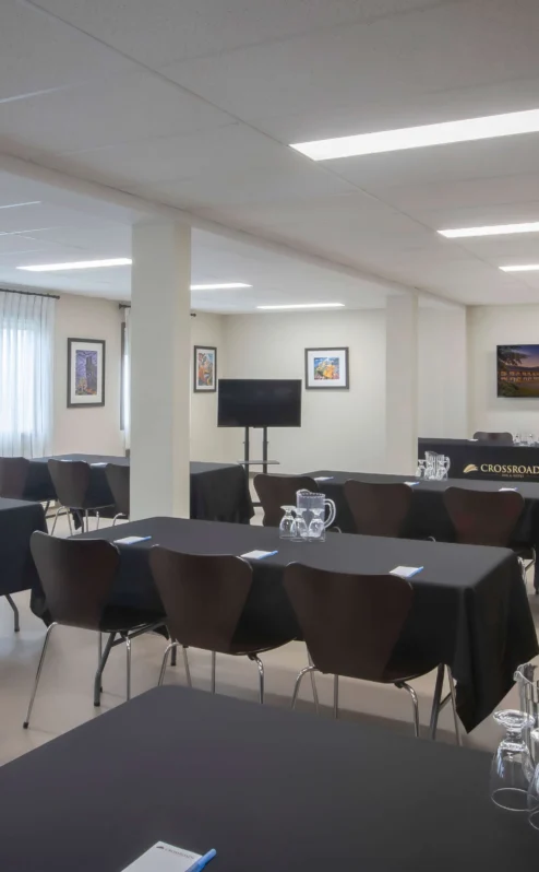 Bright, inviting conference room with tables set for a meeting at Crossroads Inn & Suites.
