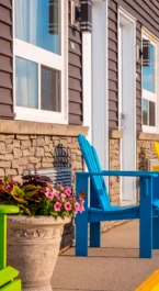 Colourful chairs outside Crossroads Inn, inviting seating with vibrant flowers.