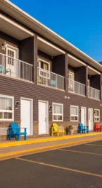 Bright, inviting inn exterior with colourful chairs and blue sky.