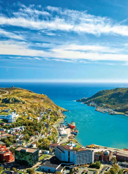 Coastal town view with blue waters and lush hills near Crossroads Inn.