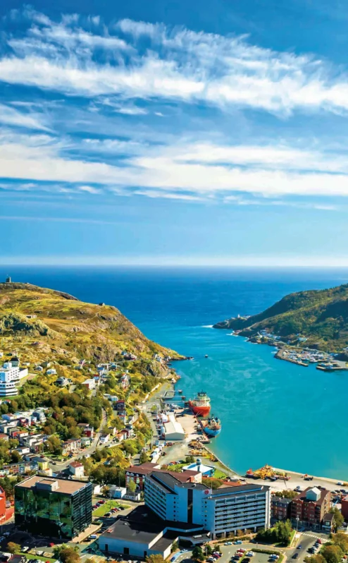 Coastal town view with blue waters and lush hills near Crossroads Inn.