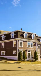Charming Crossroads Inn & Suites with colourful row houses in sunny scenic setting.