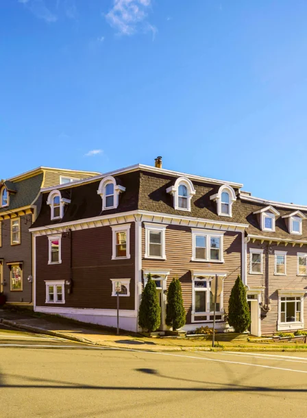 Charming Crossroads Inn & Suites with colourful row houses in sunny scenic setting.