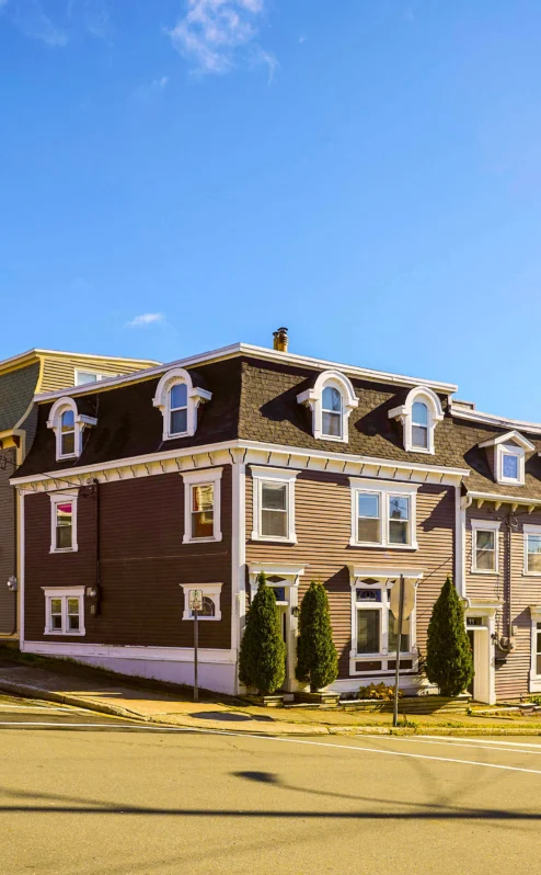 Charming Crossroads Inn & Suites with colourful row houses in sunny scenic setting.
