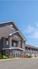 Family gathering at Crossroads Inn, sunny day, welcoming exterior with modern design.