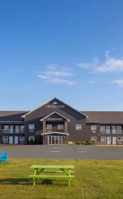 Families gather outside the charming Crossroads Inn & Suites, with flags waving in the breeze.