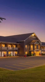 Warm, inviting exterior of Crossroads Inn & Suites at sunset with glowing lights.