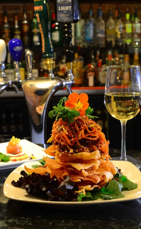 Family enjoys gourmet meal at cosy hotel bar with wine and appetisers.