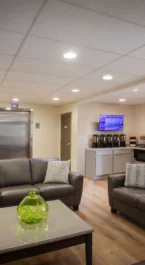 Families relax in cosy hotel lobby with fireplace at Crossroads Inn & Suites.