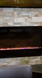 Cosy lounge area with modern fireplace and comfortable seating at Crossroads Inn & Suites.