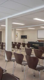 Spacious conference room setup at Crossroads Inn & Suites with chairs and presentation area.