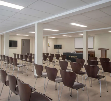 Spacious conference room setup at Crossroads Inn & Suites with chairs and presentation area.